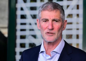 El presidente del partido Demócratas, Yair Golan, ofrece una declaración a los medios de comunicación frente al estudio de noticias del Canal 12 en Tel Aviv, después de que un asaltante destrozara las puertas de entrada del edificio durante la noche del 28 de julio de 2026. (Avshalom Sassoni/Flash90)