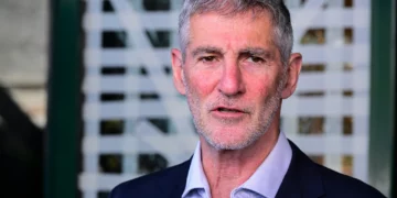 El presidente del partido Demócratas, Yair Golan, ofrece una declaración a los medios de comunicación frente al estudio de noticias del Canal 12 en Tel Aviv, después de que un asaltante destrozara las puertas de entrada del edificio durante la noche del 28 de julio de 2026. (Avshalom Sassoni/Flash90)