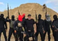 Hossam al-Astal (en el centro) aparece rodeado de miembros armados de su grupo, “Fuerza de Ataque contra el Terrorismo”, en una fotografía sin fecha tomada en la Franja de Gaza y publicada en Facebook. (Cortesía: Hossam al-Astal vía Facebook)