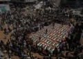 Los cuerpos de miembros de las familias Hassayna y Abu Sharia, presuntamente asesinados en un ataque israelí en 2023 y recuperados recientemente de entre los escombros, son cubiertos con banderas palestinas durante su funeral en la ciudad de Gaza, el 4 de agosto de 2026. (Foto AP/Jehad Alshrafi)