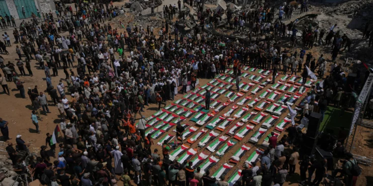 Los cuerpos de miembros de las familias Hassayna y Abu Sharia, presuntamente asesinados en un ataque israelí en 2023 y recuperados recientemente de entre los escombros, son cubiertos con banderas palestinas durante su funeral en la ciudad de Gaza, el 4 de agosto de 2026. (Foto AP/Jehad Alshrafi)