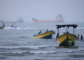 Pequeñas embarcaciones bordean la costa mientras buques de carga y otros barcos comerciales parecen estar anclados en el estrecho de Ormuz, frente a Bandar Abbas, Irán, el 27 de julio de 2026. (Razieh Poudat/ISNA vía AP)