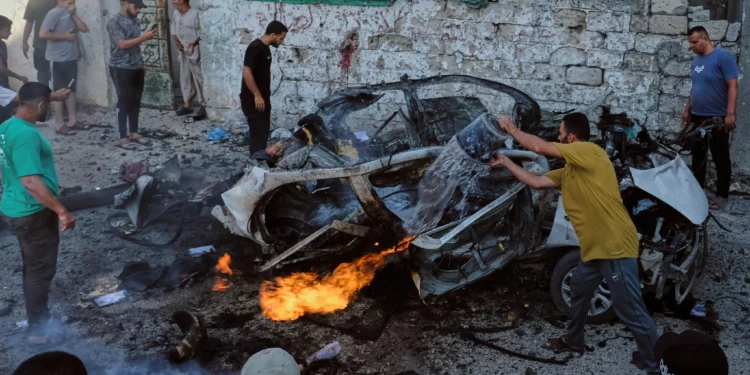Palestinians try to extinguish a burning car after an Israeli military strike in Gaza City, August 2, 2026. (AP/Jehad Alshrafi)