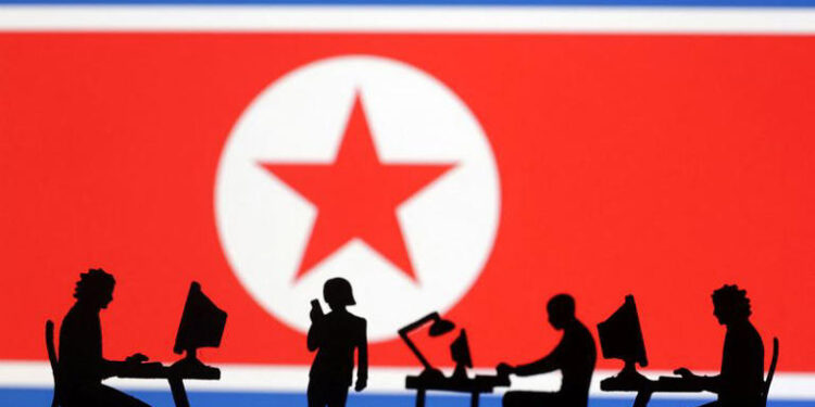En esta ilustración, tomada el 19 de julio de 2023, se ven miniaturas de personas con ordenadores frente a la bandera de Corea del Norte. Reuters/Dado Ruvic/Ilustración
