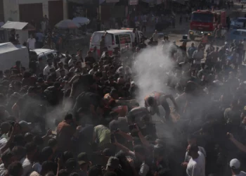 Trabajadores de rescate palestinos junto a un vehículo destruido tras un ataque aéreo israelí en la ciudad de Gaza, 19 de septiembre de 2026.
