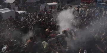 Trabajadores de rescate palestinos junto a un vehículo destruido tras un ataque aéreo israelí en la ciudad de Gaza, 19 de septiembre de 2026.