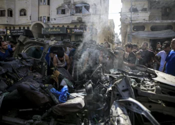 Palestinos revisan los restos y daños en el lugar de un ataque israelí contra un vehículo en el barrio Tel al-Hawa de Ciudad de Gaza, el 13 de septiembre de 2026.