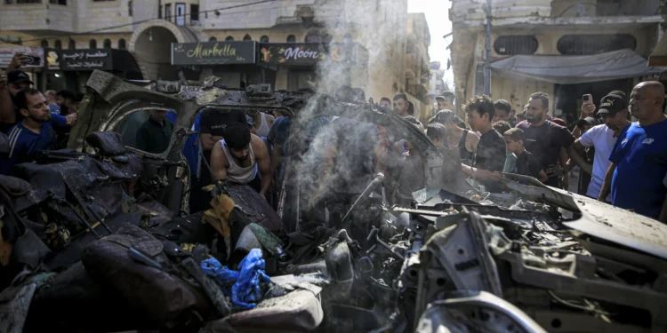 Palestinos inspeccionan los restos de un vehículo tras un ataque israelí en Tel al-Hawa, Ciudad de Gaza, el 13 de septiembre de 2026.