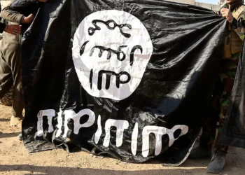 Soldados del ejército iraquí muestran una bandera del Estado Islámico capturada durante una operación cerca de Mosul, Irak, el 29 de noviembre de 2016.