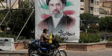 A man drives past a banner showing a portrait of Iranian Supreme Leader Ayatollah Mojtaba Khamenei, in downtown Tehran, Iran, August 31, 2026. (AP Photo/Vahid Salemi)