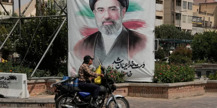 A man drives past a banner showing a portrait of Iranian Supreme Leader Ayatollah Mojtaba Khamenei, in downtown Tehran, Iran, August 31, 2026. (AP Photo/Vahid Salemi)
