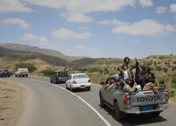 Civiles yemeníes celebran mientras viajan en la parte trasera de una camioneta en el distrito de Bani Matar, Yemen, el 12 de septiembre de 2026, durante el paso de un convoy con prisioneros hutíes liberados.