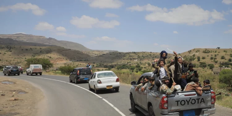 Civiles yemeníes celebran mientras viajan en la parte trasera de una camioneta en el distrito de Bani Matar, Yemen, el 12 de septiembre de 2026, durante el paso de un convoy con prisioneros hutíes liberados.