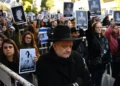 Personas sostienen fotografías de víctimas durante la ceremonia por el 31.º aniversario del atentado contra la AMIA, en Buenos Aires, el 18 de julio de 2025.