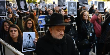 Personas sostienen fotografías de víctimas durante la ceremonia por el 31.º aniversario del atentado contra la AMIA, en Buenos Aires, el 18 de julio de 2025.