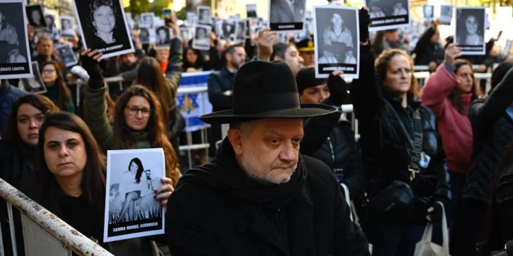 Personas sostienen fotografías de víctimas durante la ceremonia por el 31.º aniversario del atentado contra la AMIA, en Buenos Aires, el 18 de julio de 2025.
