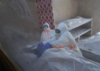 Trabajadores sanitarios preparan el cuerpo de una mujer fallecida por ébola en Bunia, Congo