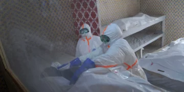 Trabajadores sanitarios preparan el cuerpo de una mujer fallecida por ébola en Bunia, Congo