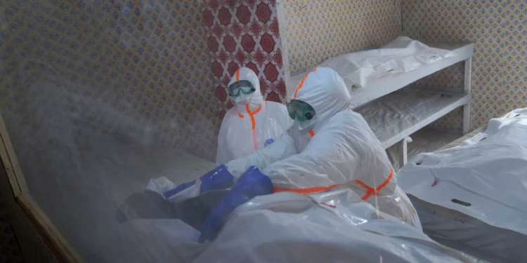 Trabajadores sanitarios preparan el cuerpo de una mujer fallecida por ébola en Bunia, Congo