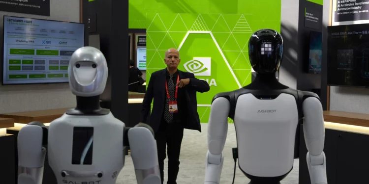 A worker stands near robots at the Nvidia booth during the China International Supply Chain Expo in Beijing on June 22, 2026. (Ng Han Guan/AP)