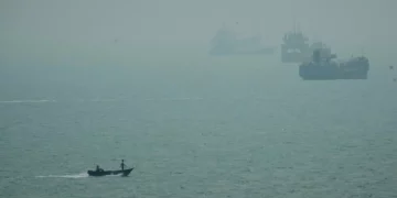 Una lancha a motor pasa junto a buques comerciales anclados en medio de la bruma en el Estrecho de Ormuz frente a Bandar Abbas, Irán, el 7 de septiembre de 2026. (AP Photo/Vahid Salemi)