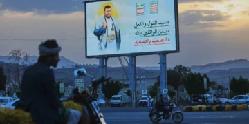 Personas circulan en motocicletas bajo un cartel del líder hutí Abdul Malik al-Houthi en Saná, Yemen, el 21 de septiembre de 2026.
