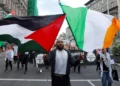 Una persona sostiene banderas de Irlanda y Palestina durante una protesta en Dublín relacionada con la guerra en Gaza.