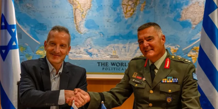 El director general del Ministerio de Defensa de Israel, Amir Baram, estrecha la mano de su homólogo griego, Ioannis Bouras, tras firmar el acuerdo de defensa en Tel Aviv.