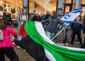 Manifestantes proisraelíes retiran una bandera de la OLP en Ámsterdam
