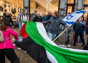 Manifestantes proisraelíes retiran una bandera de la OLP en Ámsterdam