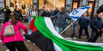 Manifestantes proisraelíes retiran una bandera de la OLP en Ámsterdam