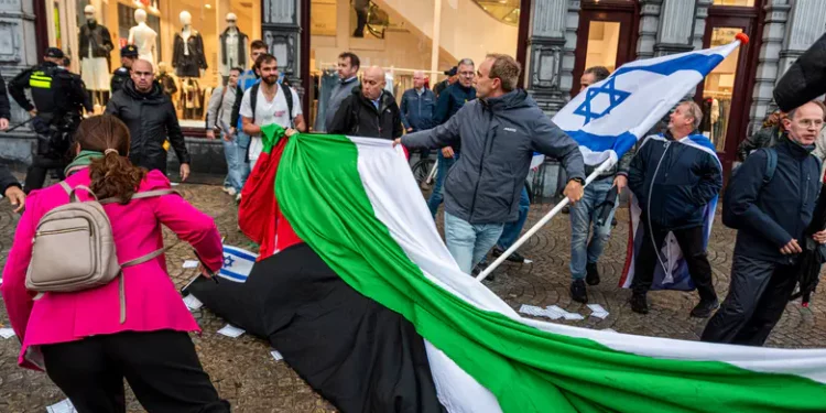 Manifestantes proisraelíes retiran una bandera de la OLP en Ámsterdam