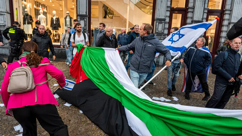 Manifestantes retiran una bandera de la OLP en Ámsterdam