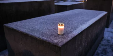 Una vela encendida sobre un bloque cubierto de escarcha en el Memorial a los Judíos Asesinados de Europa, en Berlín.