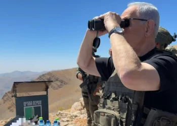 El primer ministro Benjamín Netanyahu observa con binoculares desde el monte Hermón, en el lado sirio de la frontera con Israel, el 9 de septiembre de 2026.
