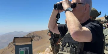 El primer ministro Benjamín Netanyahu observa con binoculares desde el monte Hermón, en el lado sirio de la frontera con Israel, el 9 de septiembre de 2026.
