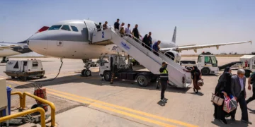 Passengers disembark an Iranian plane in Najaf airport after the end of a flight suspension caused by the regional war that began after US and Israeli strikes on Iran, in Najaf, Iraq, May 8, 2026. (AP Photo/Anmar Khalil)