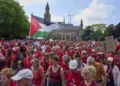 Decenas de miles de manifestantes vestidos de rojo marchan junto al Palacio de la Paz en La Haya durante una protesta contra la campaña de Israel en Gaza, el 15 de junio de 2025.