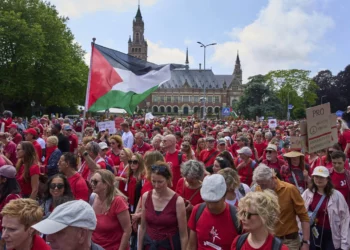 Decenas de miles de manifestantes vestidos de rojo marchan junto al Palacio de la Paz en La Haya durante una protesta contra la campaña de Israel en Gaza, el 15 de junio de 2025.