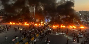 Manifestantes queman neumáticos y otros escombros para bloquear una carretera durante las protestas por el aumento del combustible en Maarat al-Numan, Idlib, el 13 de septiembre de 2026.