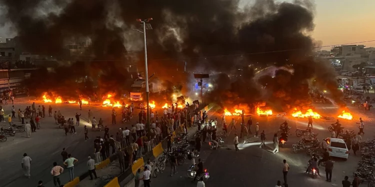Manifestantes queman neumáticos y otros escombros para bloquear una carretera durante las protestas por el aumento del combustible en Maarat al-Numan, Idlib, el 13 de septiembre de 2026.