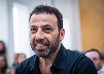 Raviv Drucker al volante con un teléfono móvil en la mano