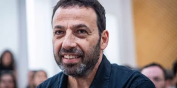 Raviv Drucker al volante con un teléfono móvil en la mano