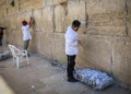 Trabajadores retiran notas de oración escritas a mano colocadas entre las antiguas piedras del Kotel en la Ciudad Vieja de Jerusalén, 6 de septiembre de 2026.