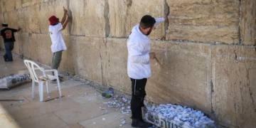 Trabajadores retiran notas de oración escritas a mano colocadas entre las antiguas piedras del Kotel en la Ciudad Vieja de Jerusalén, 6 de septiembre de 2026.
