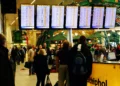 Pasajeros observan pantallas con vuelos retrasados y cancelados en el aeropuerto Schiphol de Ámsterdam.
