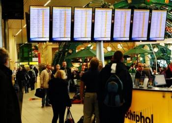 Pasajeros observan pantallas con vuelos retrasados y cancelados en el aeropuerto Schiphol de Ámsterdam.