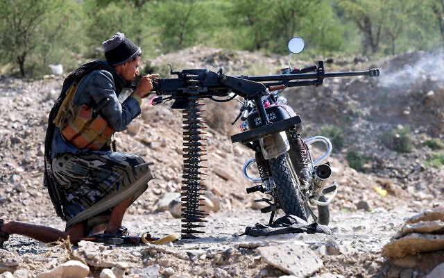 Un combatiente del gobierno yemení reconocido internacionalmente dispara una ametralladora instalada en una motocicleta en Taiz.