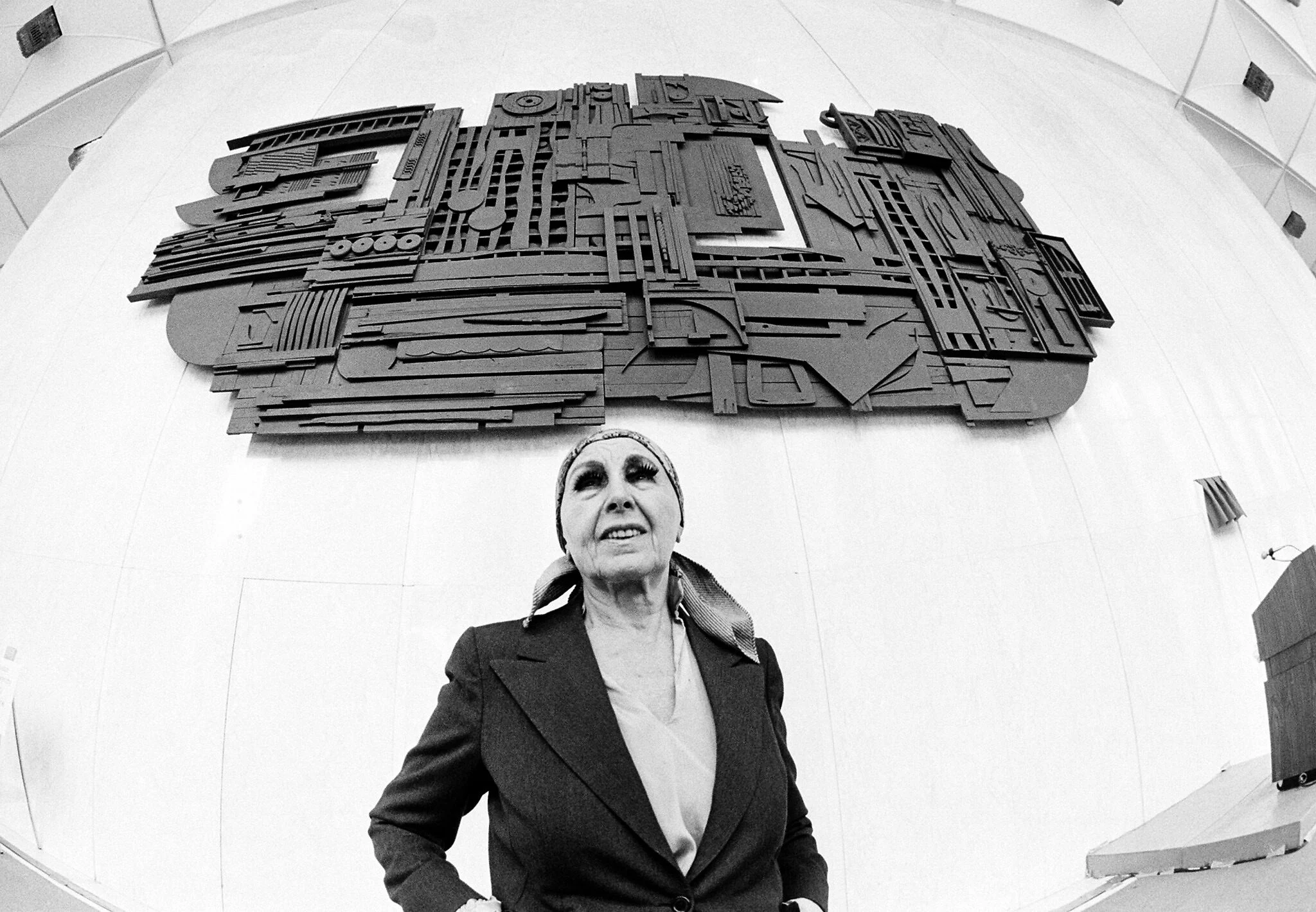Louise Nevelson posa bajo su obra Sky Gate, New York, durante su presentación en 1978