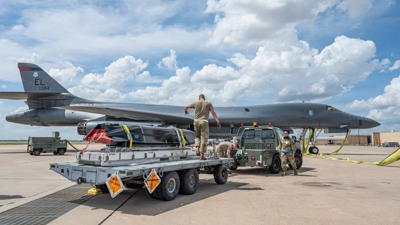 Personal de la Fuerza Aérea traslada un misil AGM-158C LRASM hacia un B-1B Lancer.